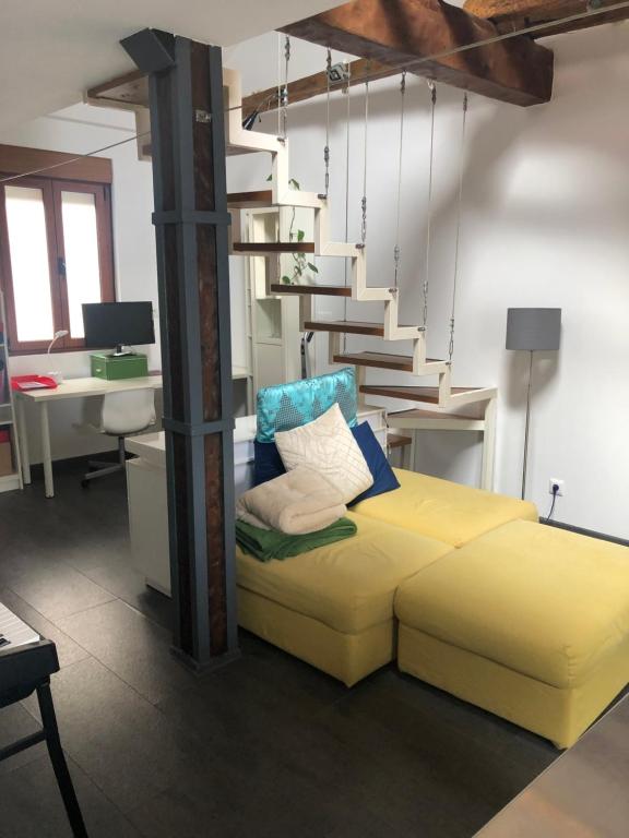een kamer met een geel bed en een trap bij Loft Adrimar in Santoña
