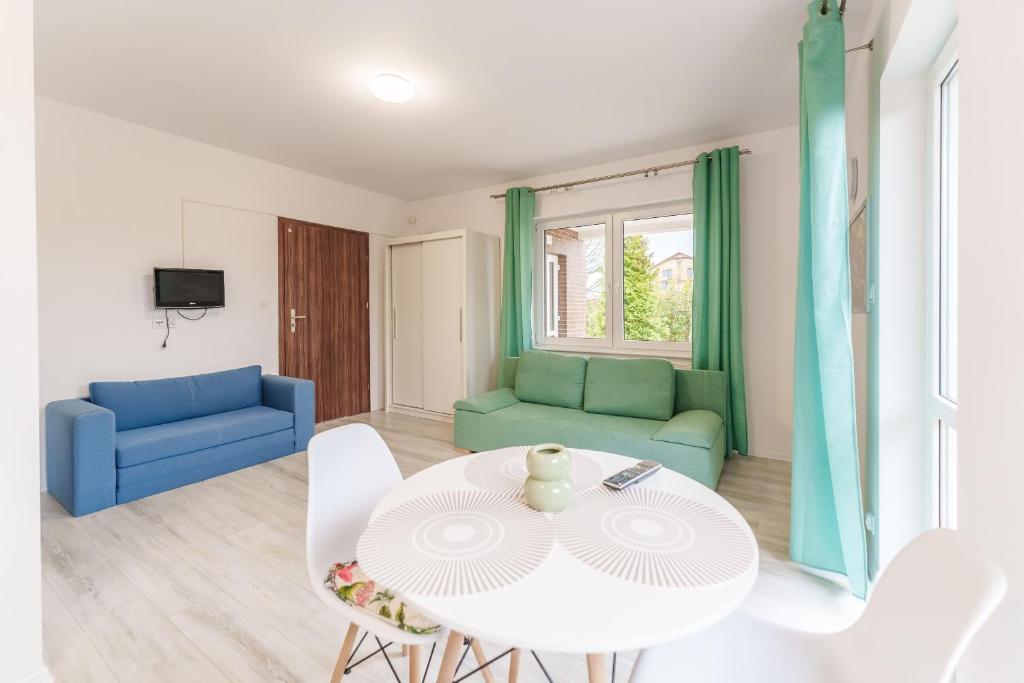 sala de estar con mesa blanca y sillas en Nadmorski Apartament I by Holiday&Sun, en Grzybowo