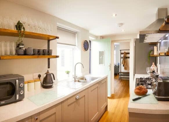 a kitchen with a sink and a microwave at Sandholme Cottage - Central location great for families in Filey