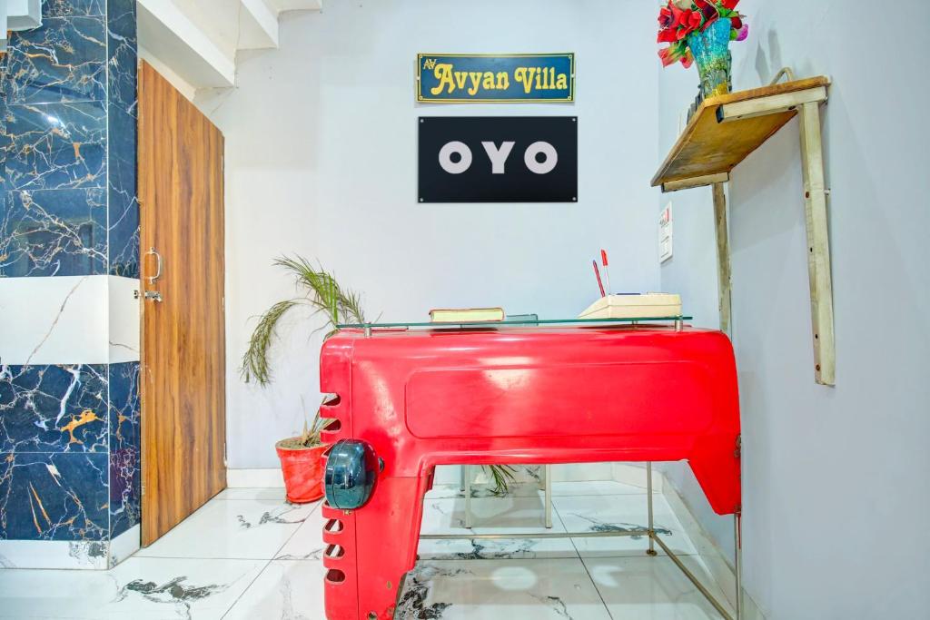 a red suitcase in a room with a sign on the wall at OYO AVYAN VILLA in Lālewāl