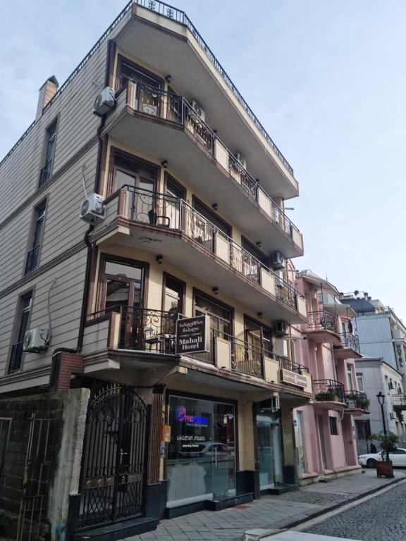 an apartment building with balconies on a street at MAHALI HOTEL in Batumi