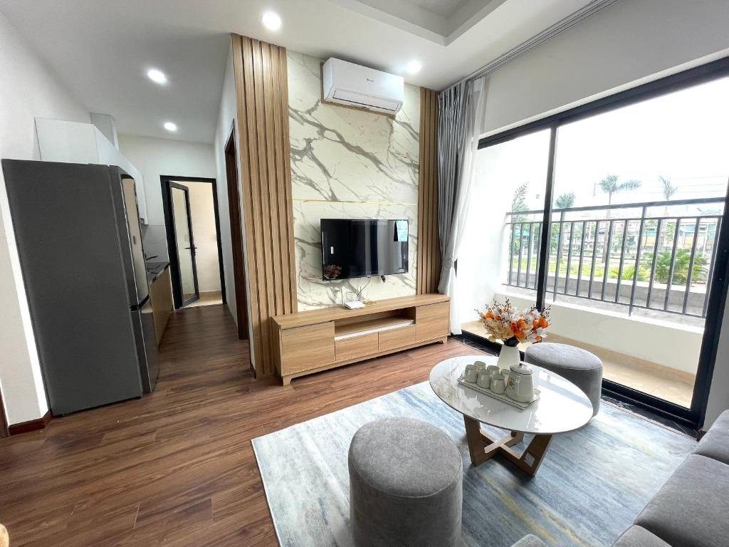 a living room with a tv and a couch and a table at Asahi Luxstay - Apartment Luxcity Cẩm Phả in Hòn Một