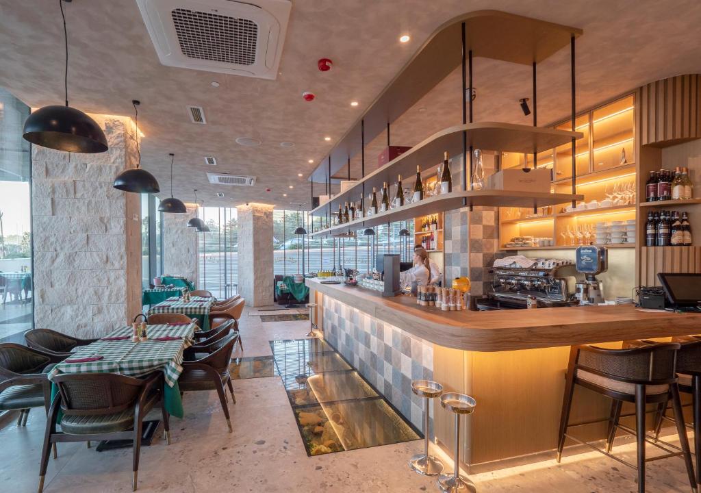a restaurant with a bar and some tables and chairs at Sea Star Budva in Budva