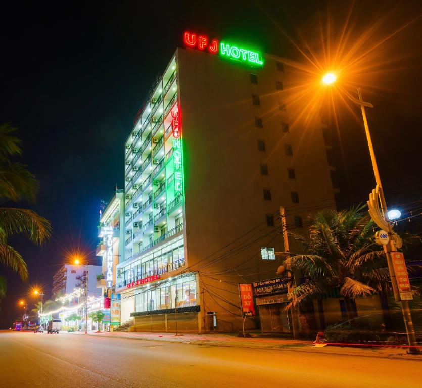 budynek z znakiem hotelowym na górze w nocy w obiekcie UFJ HOTEL Sầm Sơn w mieście Sam Son