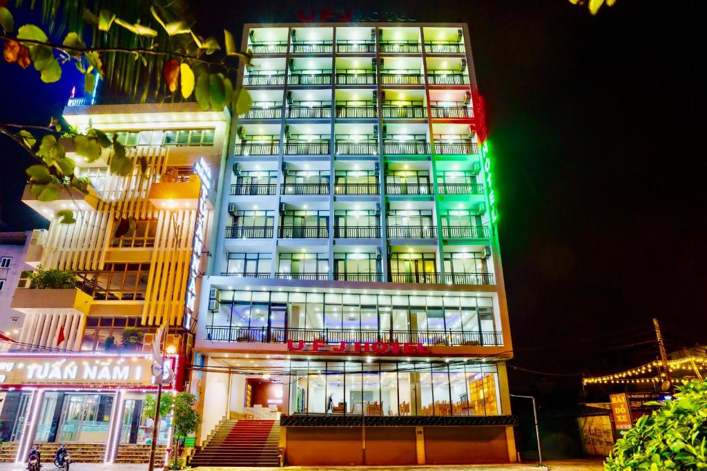 a tall building with green lights on it at UFJ HOTEL Sầm Sơn in Sầm Sơn