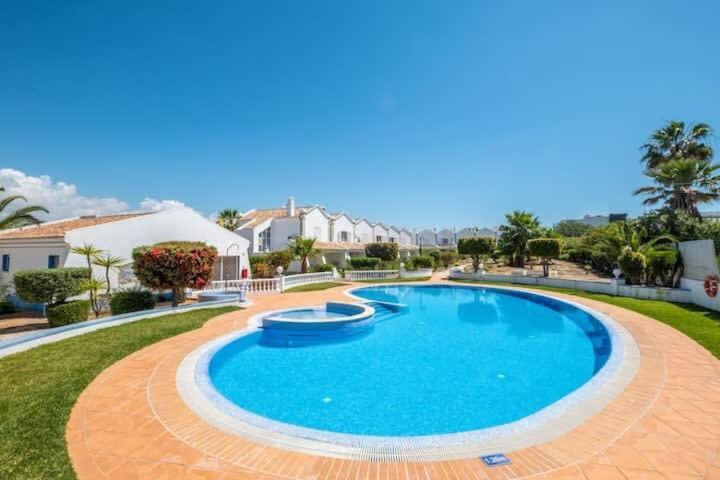 een groot zwembad in een tuin met huizen bij Villa Baya - Great family complex with communal pool in Albufeira