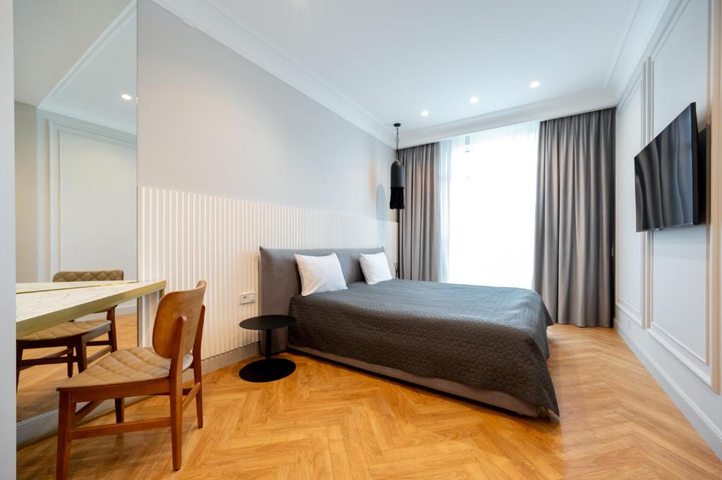 ein Schlafzimmer mit einem Bett, einem Tisch und einem Schreibtisch in der Unterkunft Vintage Apartments in Odessa