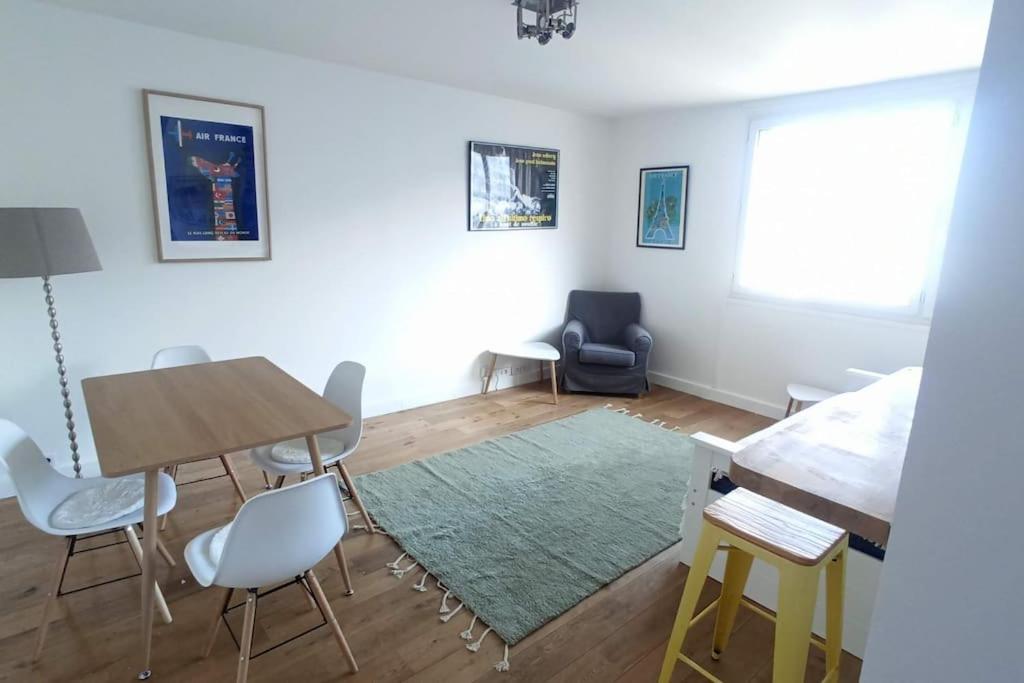 un salon avec une table et des chaises dans l'établissement 2-pièces clair et calme, idéal Jeux Olympiques !, à Clichy