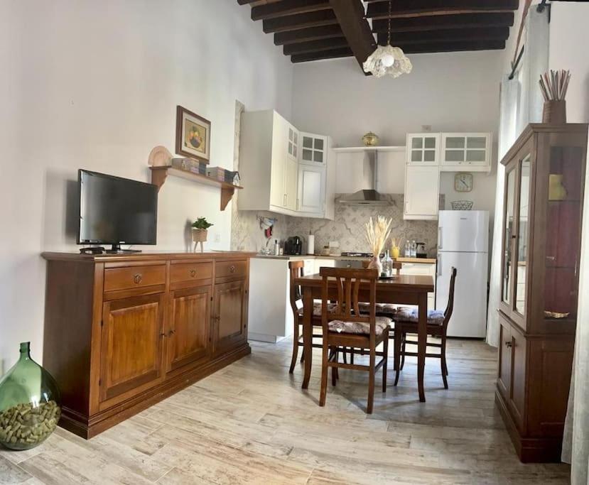 a kitchen with a table and chairs and a television at La Casa degli Artisti, appartamento in centro storico in Montepulciano