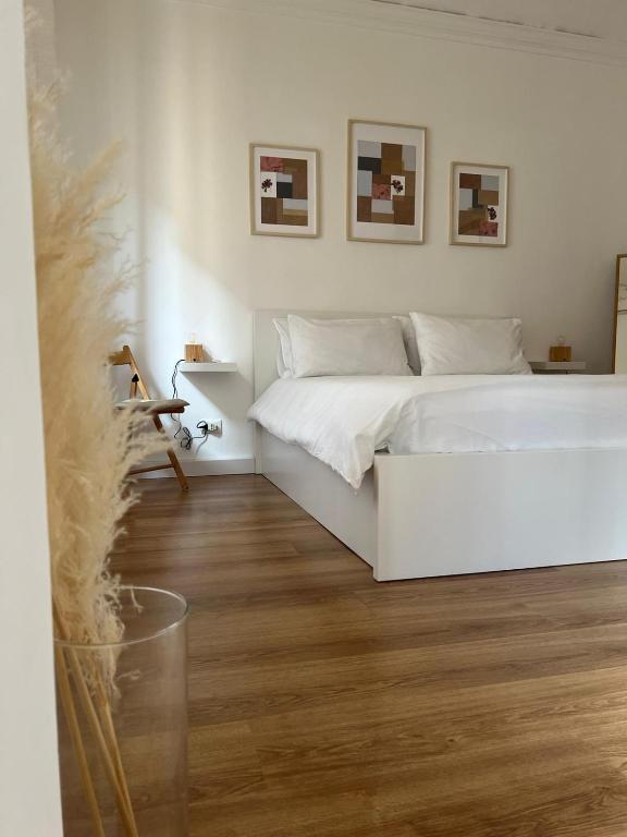 - une chambre avec un lit blanc et du parquet dans l'établissement Casa Belfiore 1892 - bilocale, à Turin
