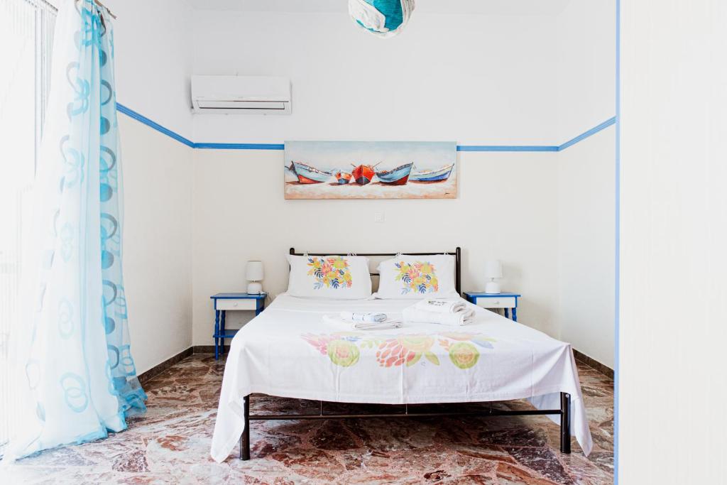 a bedroom with a bed with a white bedspread at Mavromati Rooms 2 in Kiveri