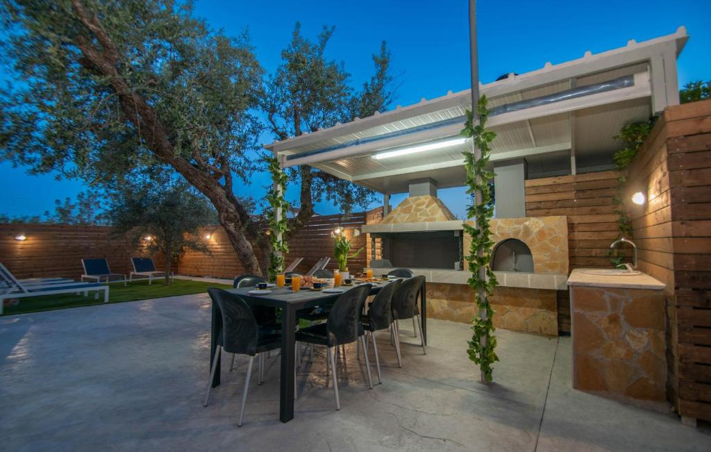 Villa Erato Family في Mouzákion: فناء مع طاولة وكراسي أمام المنزل