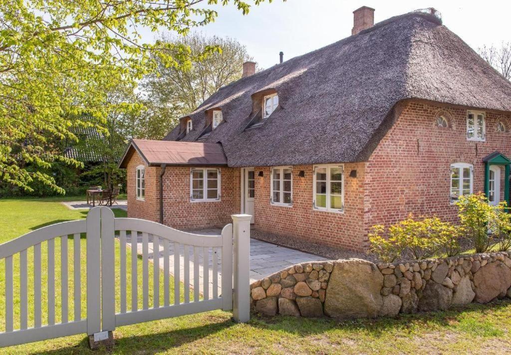 a white fence in front of a brick house at Hartelk in Nebel