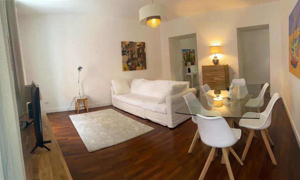 ein Wohnzimmer mit einem weißen Sofa und einem Glastisch in der Unterkunft Palazzo Venezian 5 in Triest