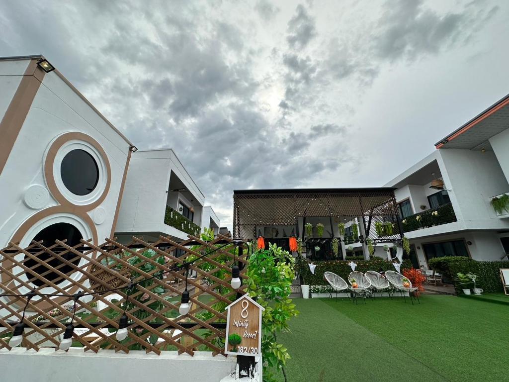 ein Haus mit einem Garten mit Stühlen und einem Zaun in der Unterkunft Infinity Resort Kohlarn in Ko Larn