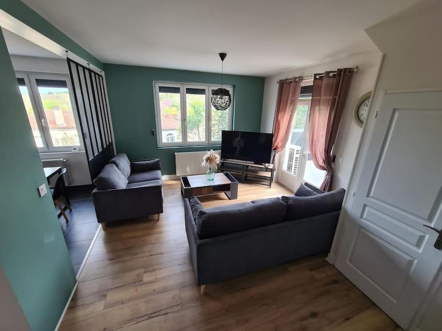 ein Wohnzimmer mit Sofa und Tisch in der Unterkunft Maison rénovée 4 chambres. in Angoulême