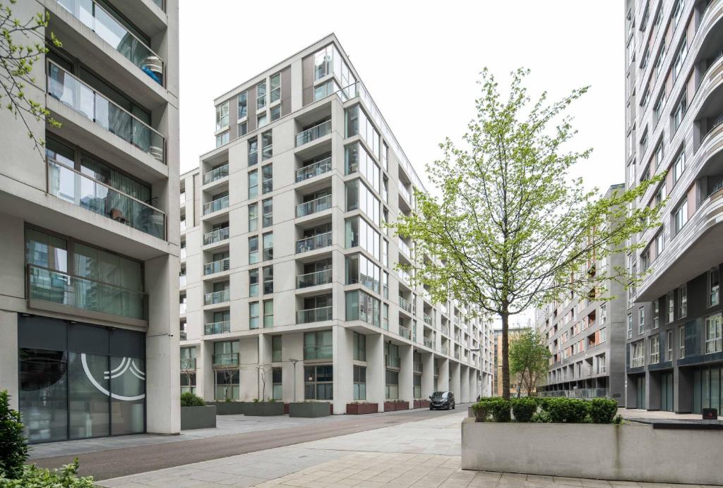 a tall white building with a tree in front of it at Immaculate 1-Bed Apartment in London in London