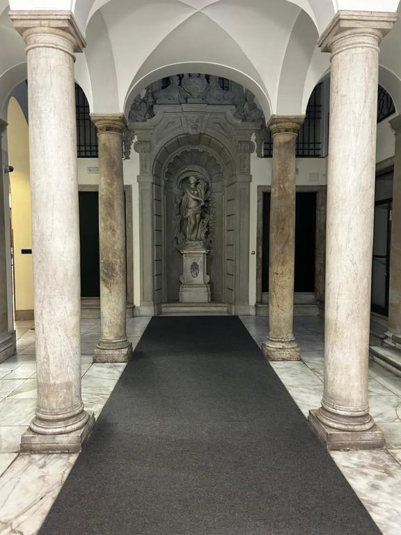 a hallway with columns and a statue in a building at Le Colonne Di San Luca in Genova