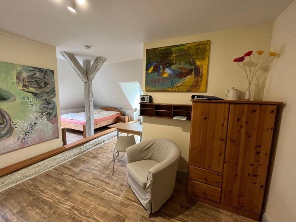 a living room with a chair and a bedroom at 2 Ferienwohnung - Ferien Mittendrin in Schwerin