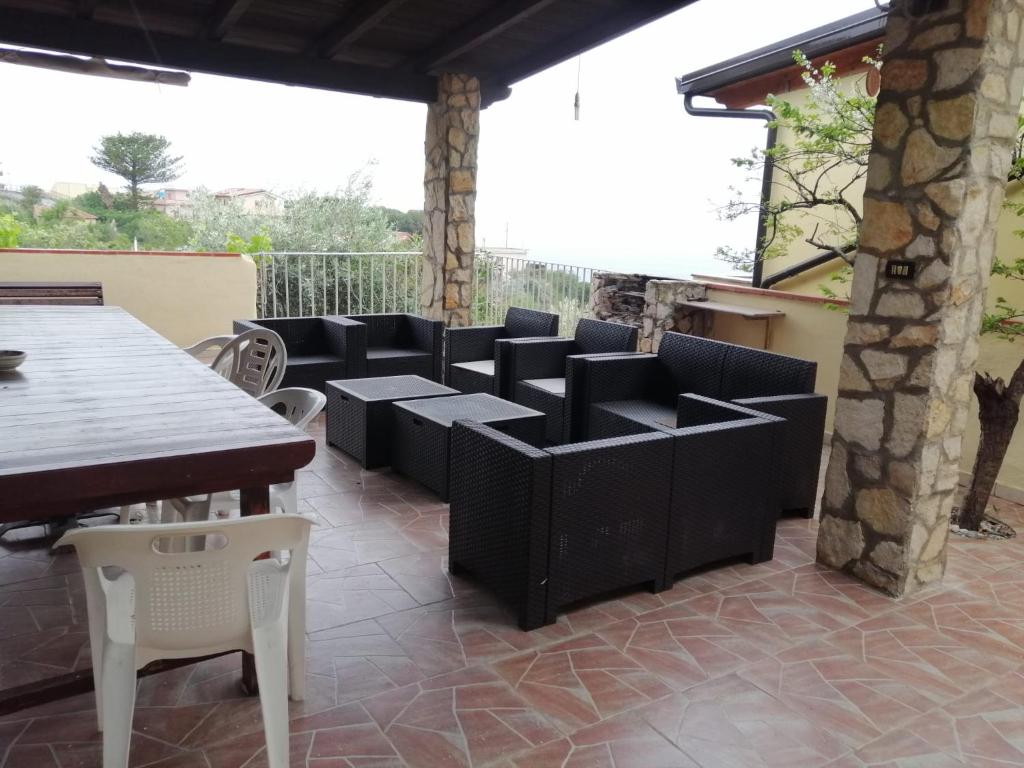 patio z czarnymi meblami, stołem i krzesłami w obiekcie Casa Chiara w mieście Scilla