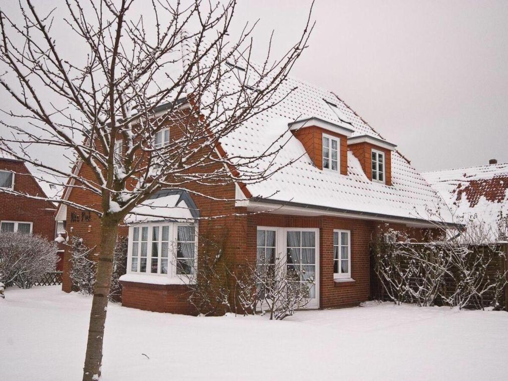 a brick house with a snow covered roof at Welkimmen in Nebel