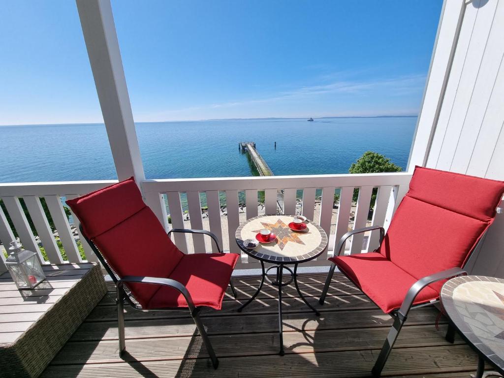 two chairs and a table on a balcony with the ocean at Fürstenhof - Ferienwohnung 204 in Sassnitz
