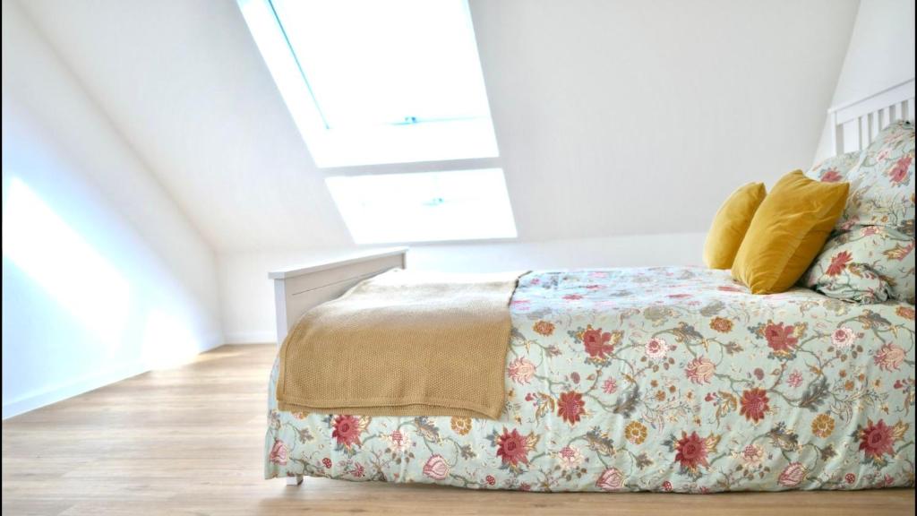 a bedroom with a bed with a floral bedspread at Land-Apartments Netphen in Netphen