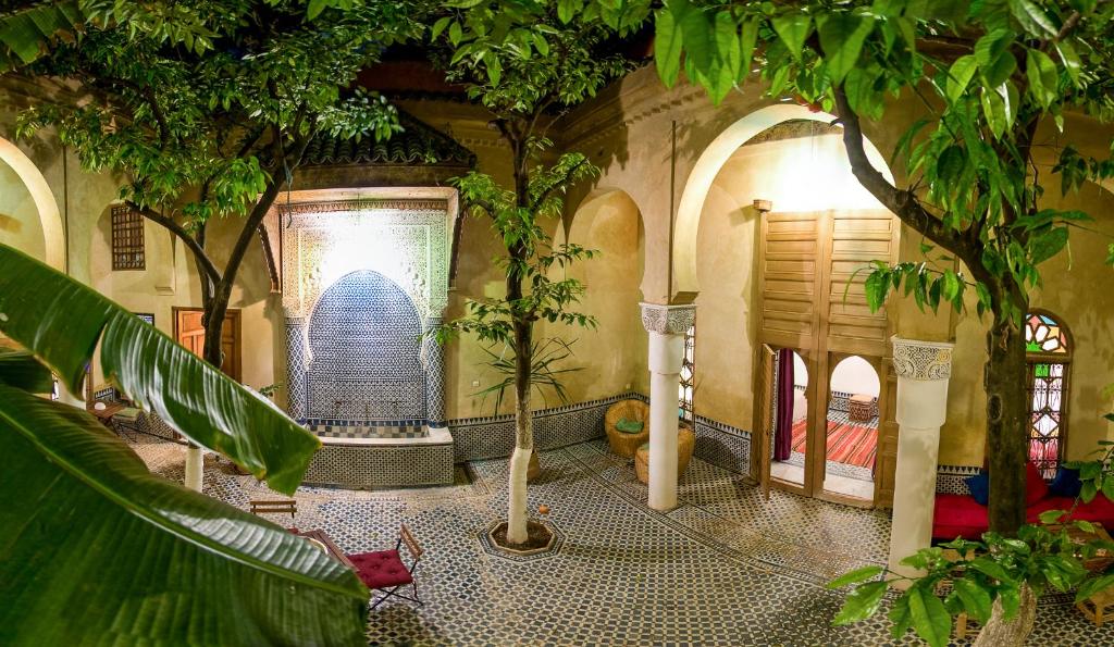 a room with a room with trees and a building at Riad La Maison D'à Côté in Meknès