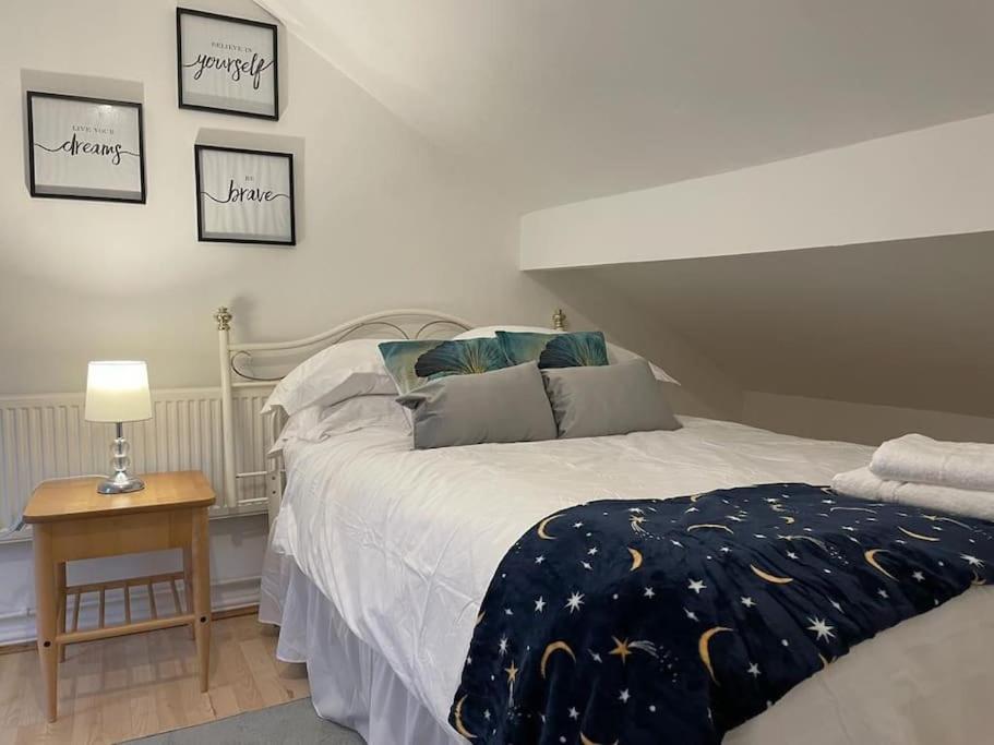 - une chambre avec un lit et une table avec une lampe dans l'établissement 3 Bedroom Home In Stoke, à Stoke-on-Trent