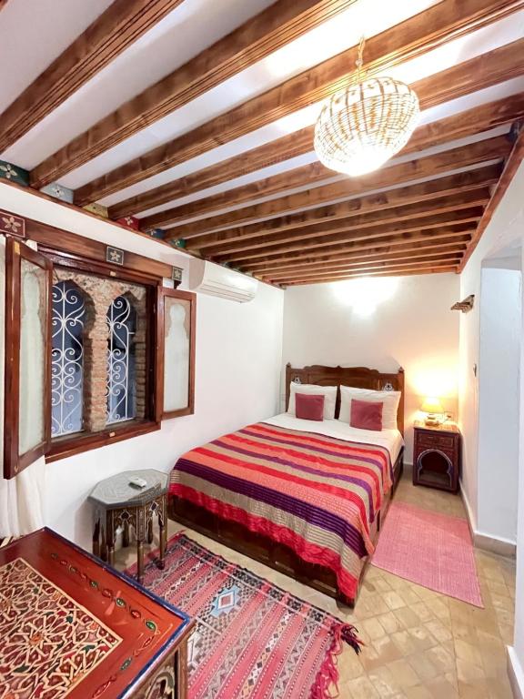 Schlafzimmer mit einem Bett und einem Kronleuchter in der Unterkunft Dar Sababa in Chefchaouen