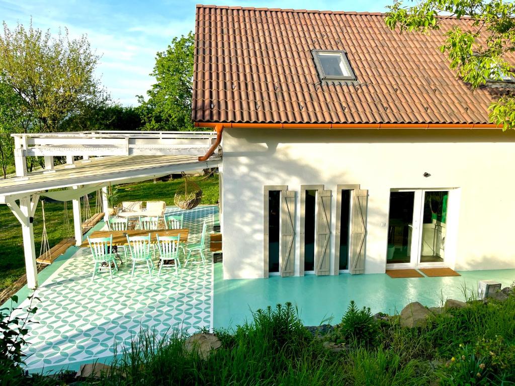 uma pequena casa com uma piscina e um deque em Bohemian lodge em Kisapáti