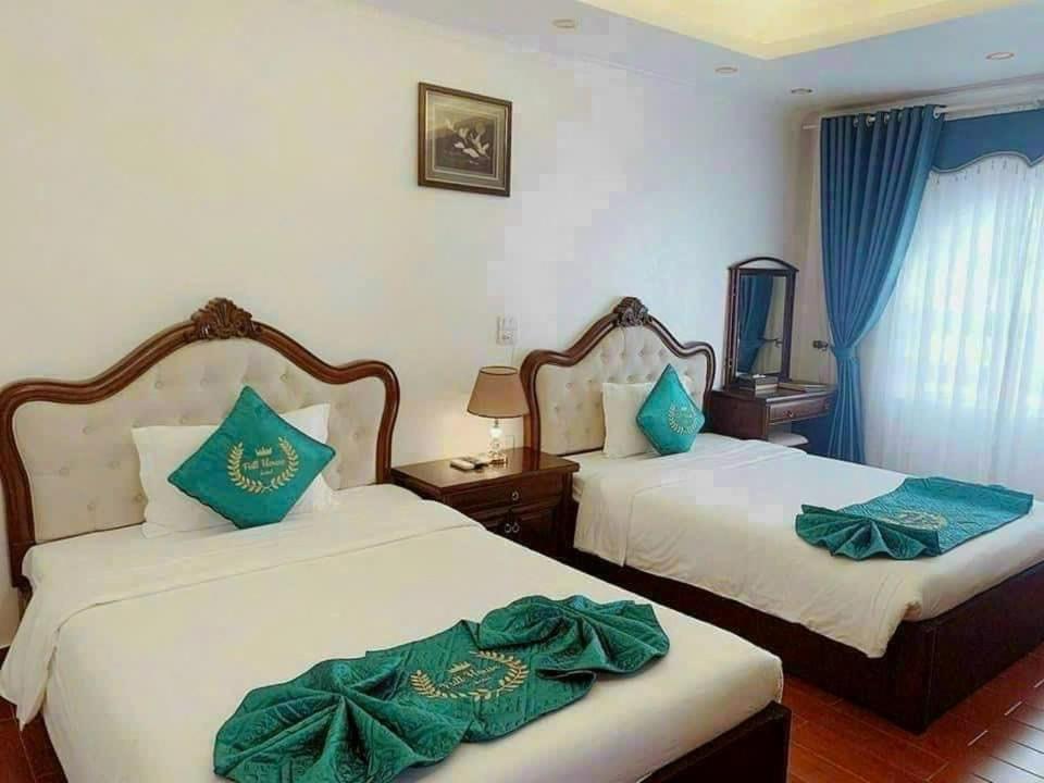 2 camas en una habitación de hotel con almohadas verdes en FULL HOUSE Hotel, en Ðong Thon