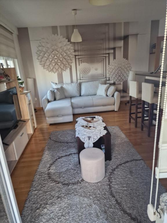 ein Wohnzimmer mit einem Sofa und einem Tisch in der Unterkunft Apartment Lux Lomina in Čačak