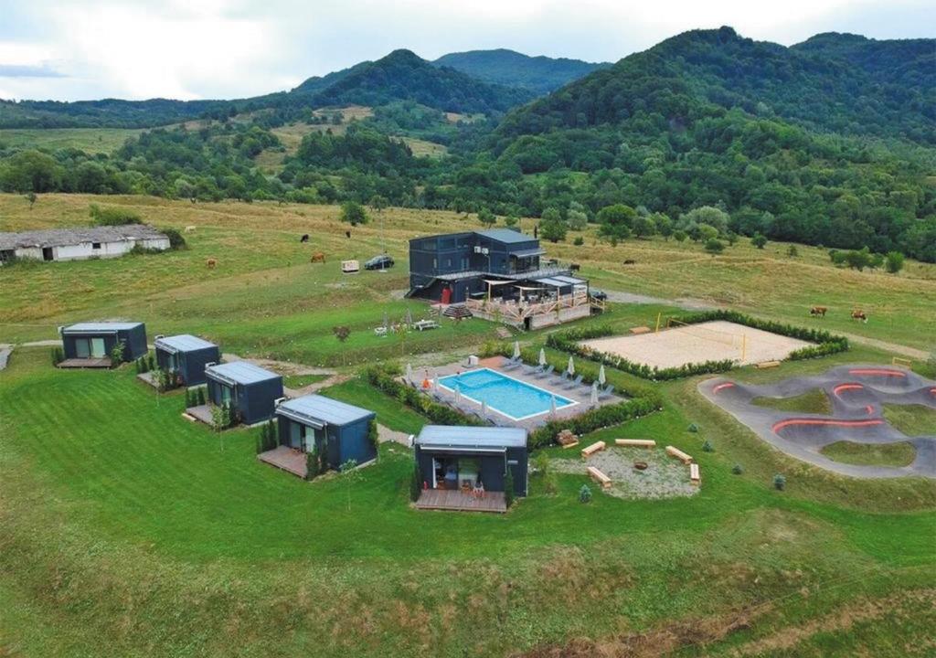 - une vue aérienne sur une ferme avec une maison et une piscine dans l'établissement FLANDRA Glamping, à Corbeni