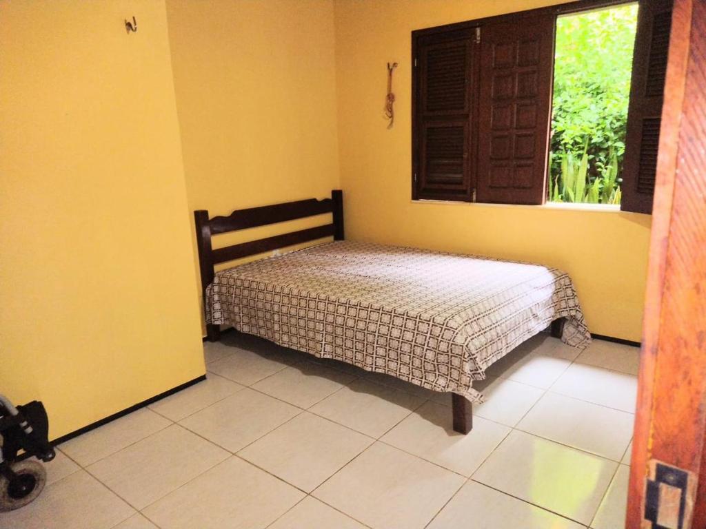 ein Schlafzimmer mit einem Bett in einem Zimmer mit einem Fenster in der Unterkunft Sitio vó Dora in Aratuba