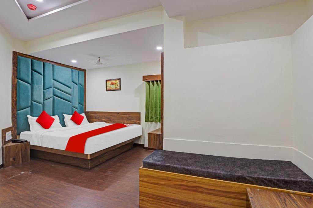 1 dormitorio con 1 cama con almohadas rojas en OYO Flagship Hotel Swagat Inn, en Ahmedabad