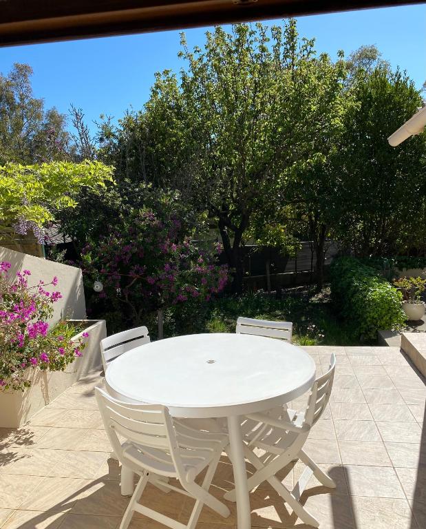 une table blanche et des chaises sur une terrasse dans l'établissement Maison à 150m de la plage naturiste, 2 chambres, à Linguizzetta