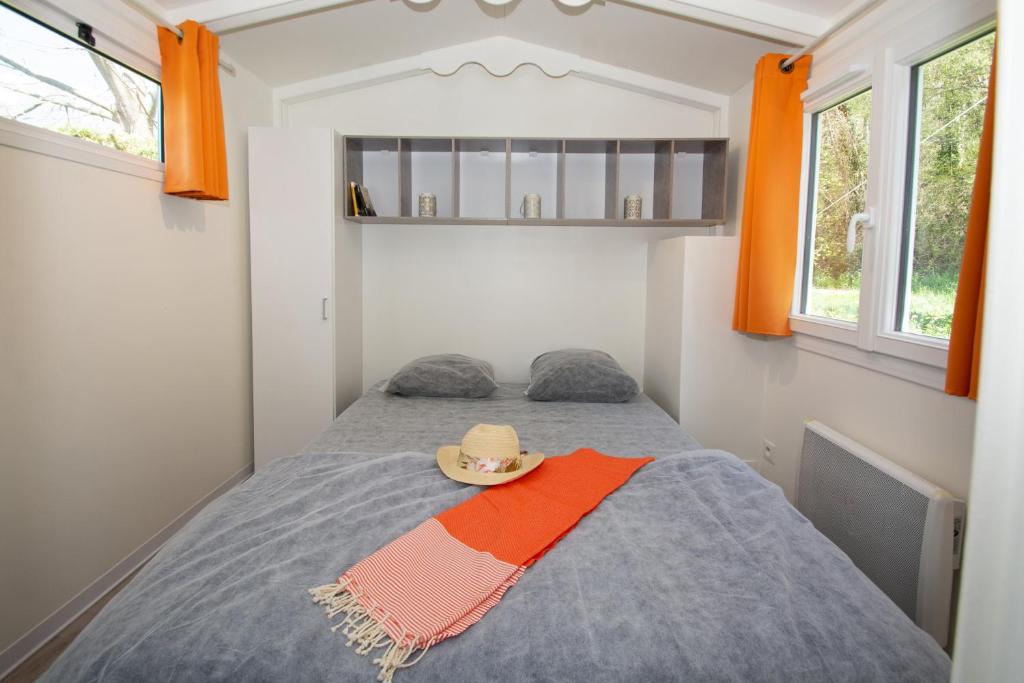 une chambre avec un lit avec un chapeau dessus dans l'établissement A La Rencontre Du Soleil - Camping, au Bourg-dʼOisans