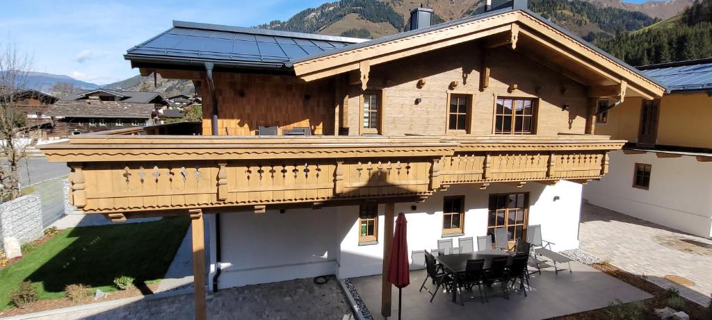 Cette maison dispose d'un balcon avec une table et des chaises. dans l'établissement Hochalmbahnen Chalets Rauris 1-15 WE1, Maislaufeldweg 1o EG, à Rauris