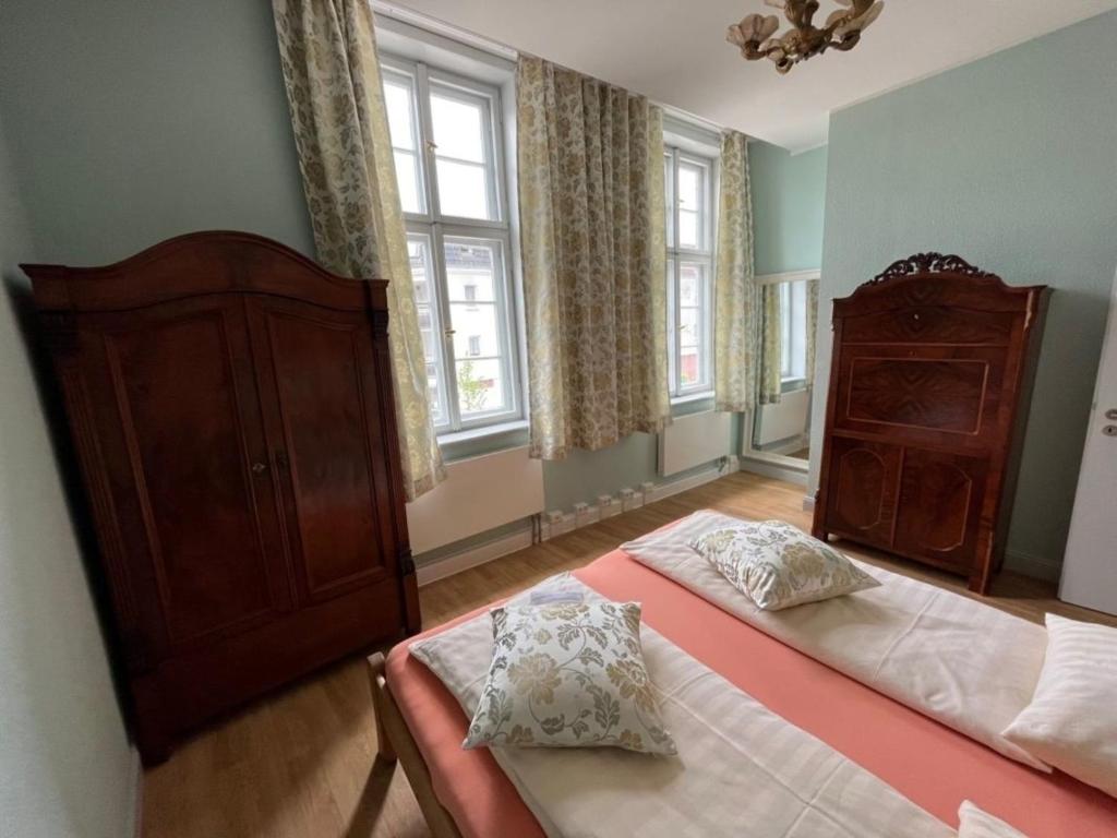a bedroom with two beds and a dresser and windows at 7 Ferienwohnung - Ferien Mittendrin in Schwerin