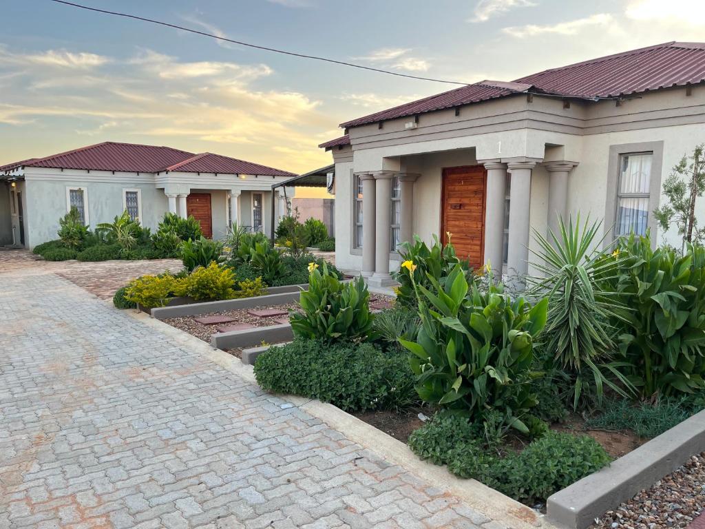 a row of houses with a brick driveway at Mafikeng Boutique Lodge in Mahikeng