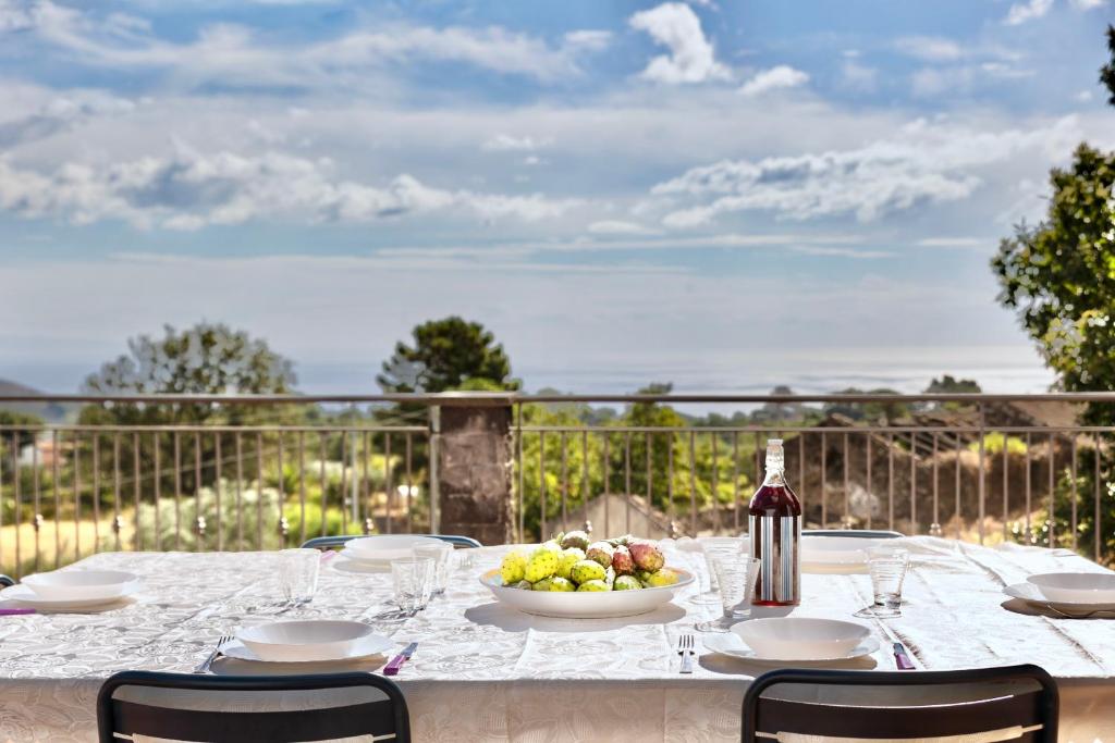 une table avec un bol de fruits et une bouteille de vin dans l'établissement Villa MELANY Casa Vacanza, à Piedimonte Etneo 50 autres photos