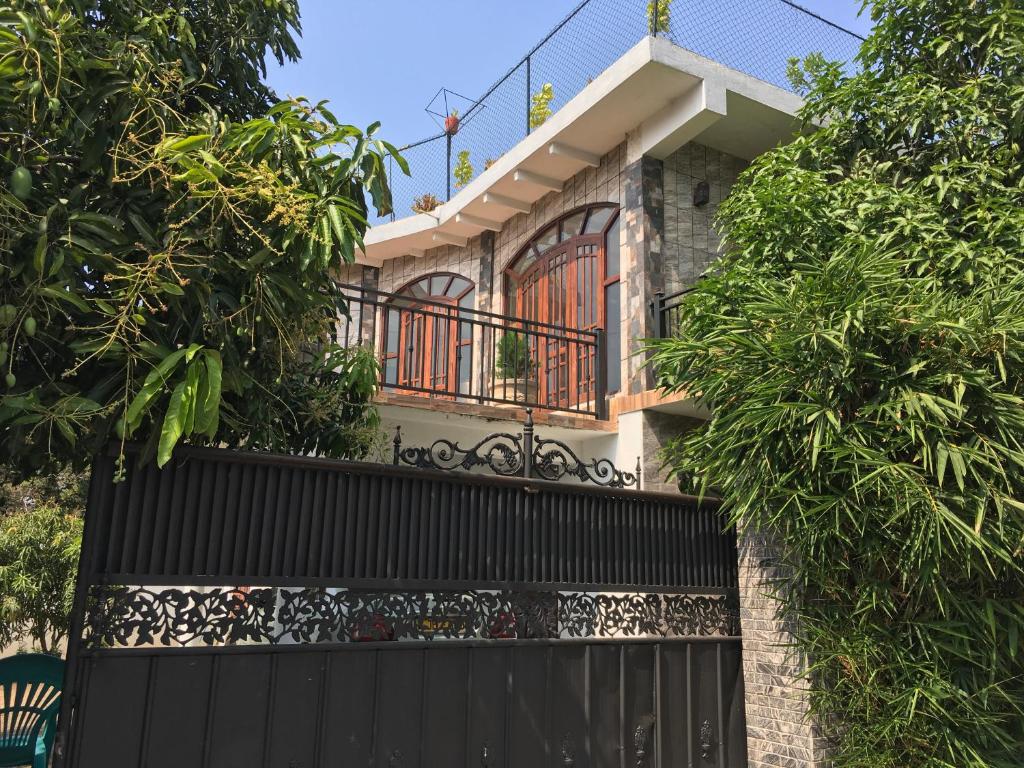 a house with a black gate and trees at Moon Deck Villa in Katunayake