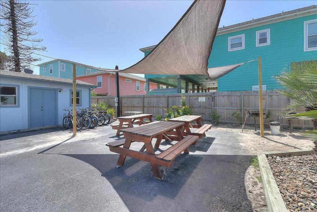 un groupe de tables de pique-nique devant un bâtiment dans l'établissement Pompano (Mustang Isle #20), à Port Aransas