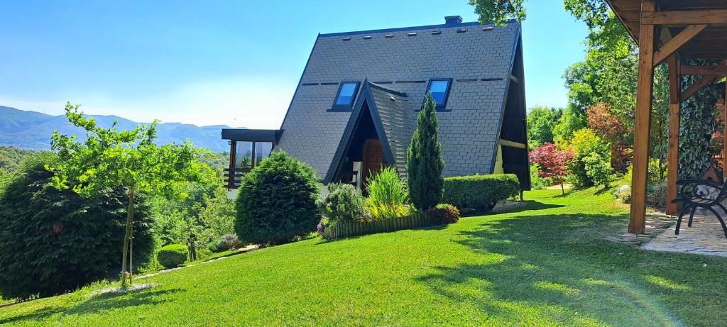 una casa en una colina con un patio verde en Kuća za odmor Bitoševje en Klenovnik