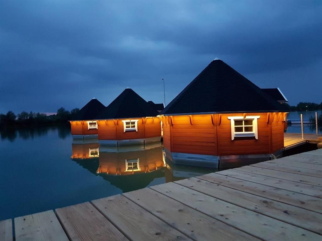 ein Holzhaus auf dem Wasser in der Nähe eines Docks in der Unterkunft Maritime Freizeit Camp "MFC" Erfurter Seen in Stotternheim