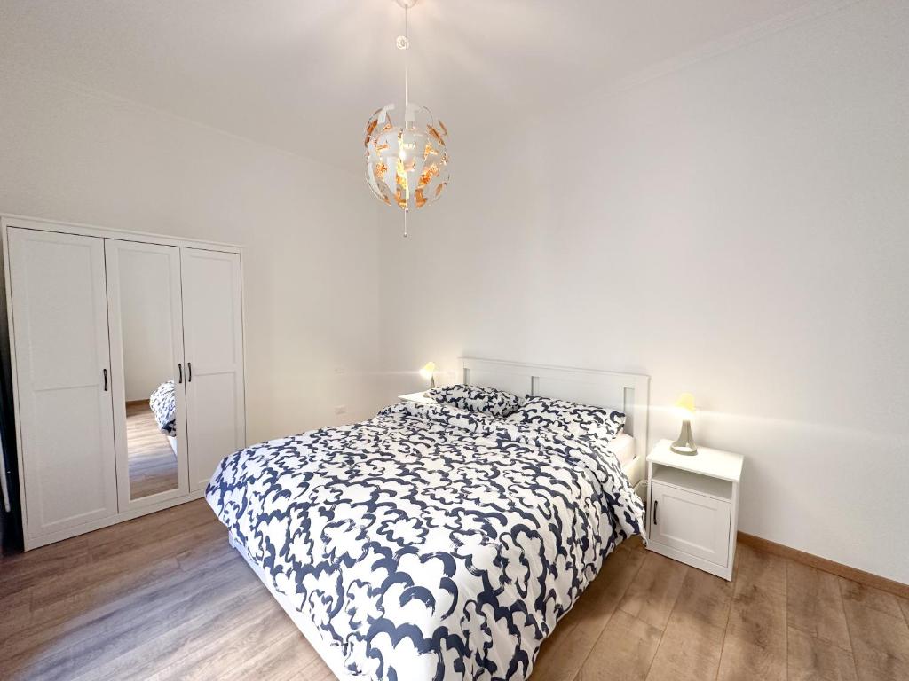 um quarto branco com uma cama e um lustre em A few steps from the port of Nervi em Gênova