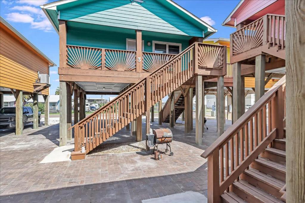 a house with wooden stairs leading up to a building at Blue Marlin Cottage (Anchor Courts #3) in Port Aransas