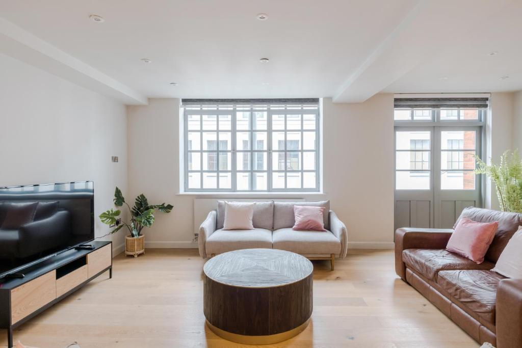 a living room with two couches and a coffee table at Circus of Colour - Farringdon - by Frankie Says in London