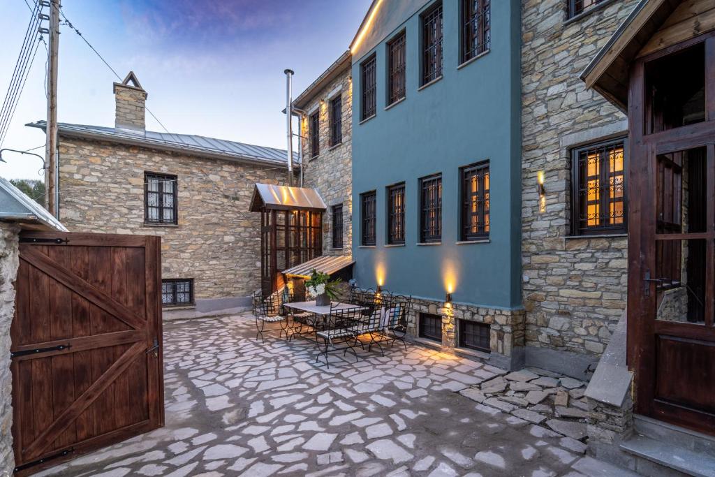 un patio al aire libre con una mesa y una puerta de granero en Dandy Villas Nymfaio - Snow Queen - Sauna - Fireplace - Up to 6 adults 2kids, en Nymfaio